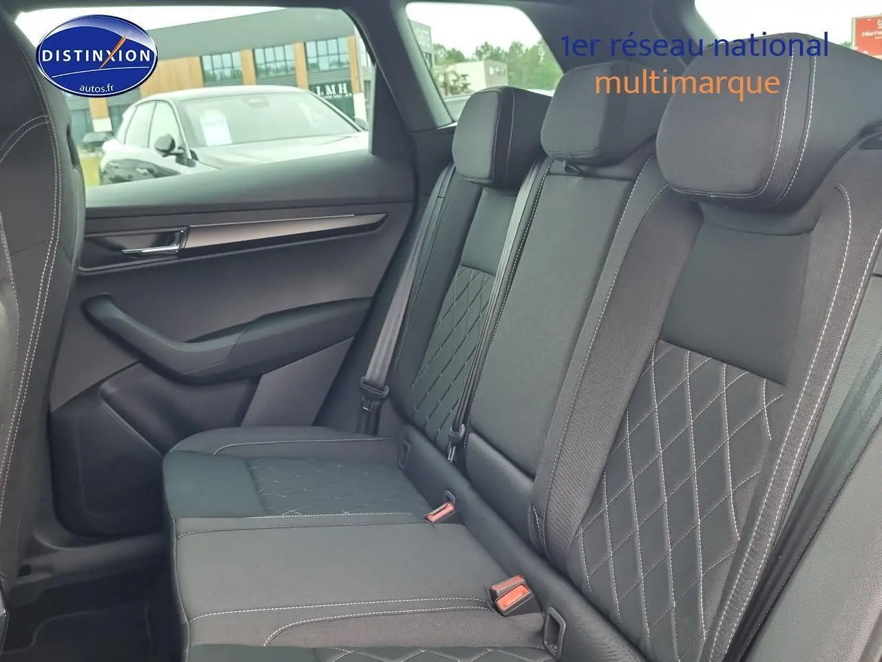 Vue latérale droite de l'intérieur arrière noir du Skoda Karoq 1.5 TSI 150 Sportline avec sièges en tissu matelassé.