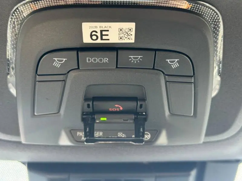 Vue rapprochée du plafonnier noir de la Toyota Corolla 2025 avec boutons d’éclairage et alerte SOS ouverte.