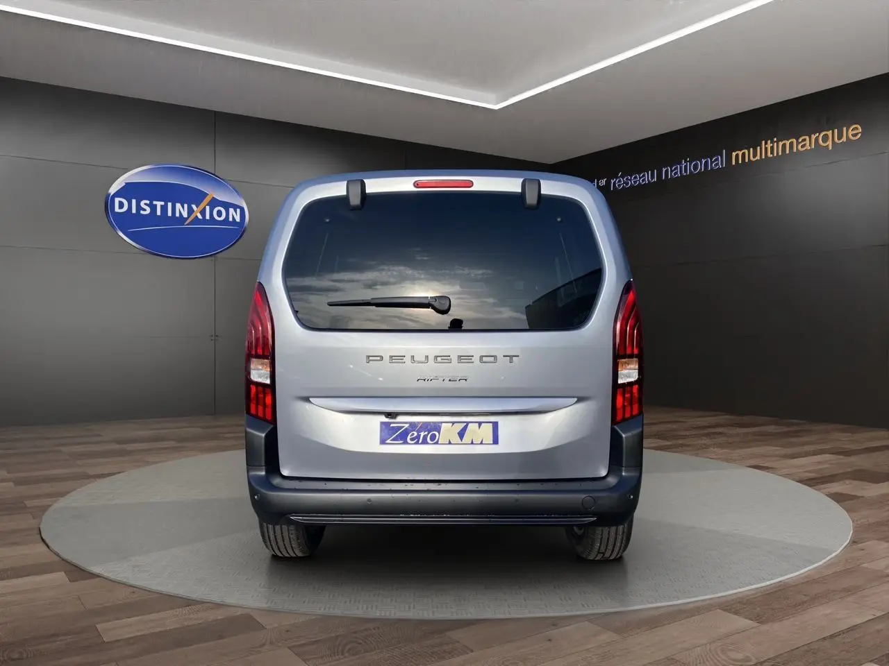 Vue arrière du Peugeot Rifter gris acier 2026 avec hayon vitré et feux verticaux LED distinctifs.