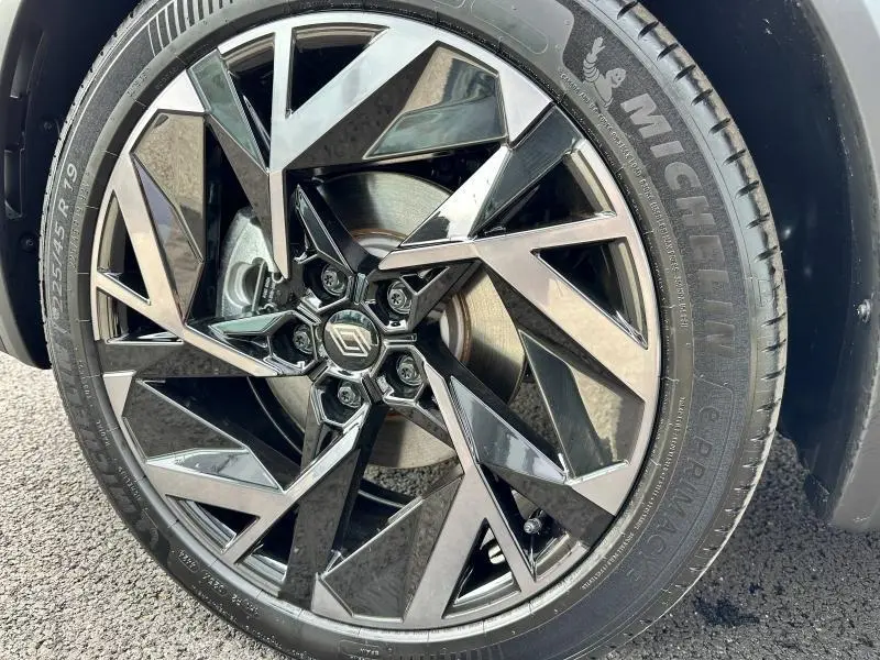 Gros plan sur la roue avant droite du Renault Captur 2025, jante alliage noire et argentée au design géométrique distinctif.