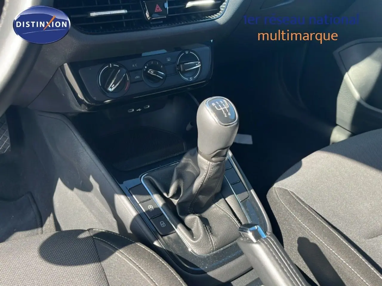 Gros plan sur la console centrale de la Skoda Fabia noire, montrant le levier de vitesses manuel et les commandes de climatisation.
