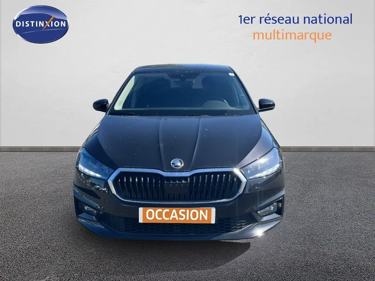 Vue frontale d'une Skoda Fabia noire métal 2025 avec calandre chromée et phares LED allumés.