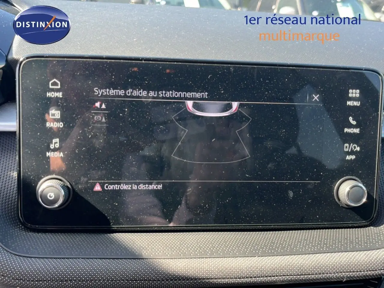 Écran tactile du système d'aide au stationnement de la Skoda Fabia 2025, finition noire, affichage clair et boutons latéraux.