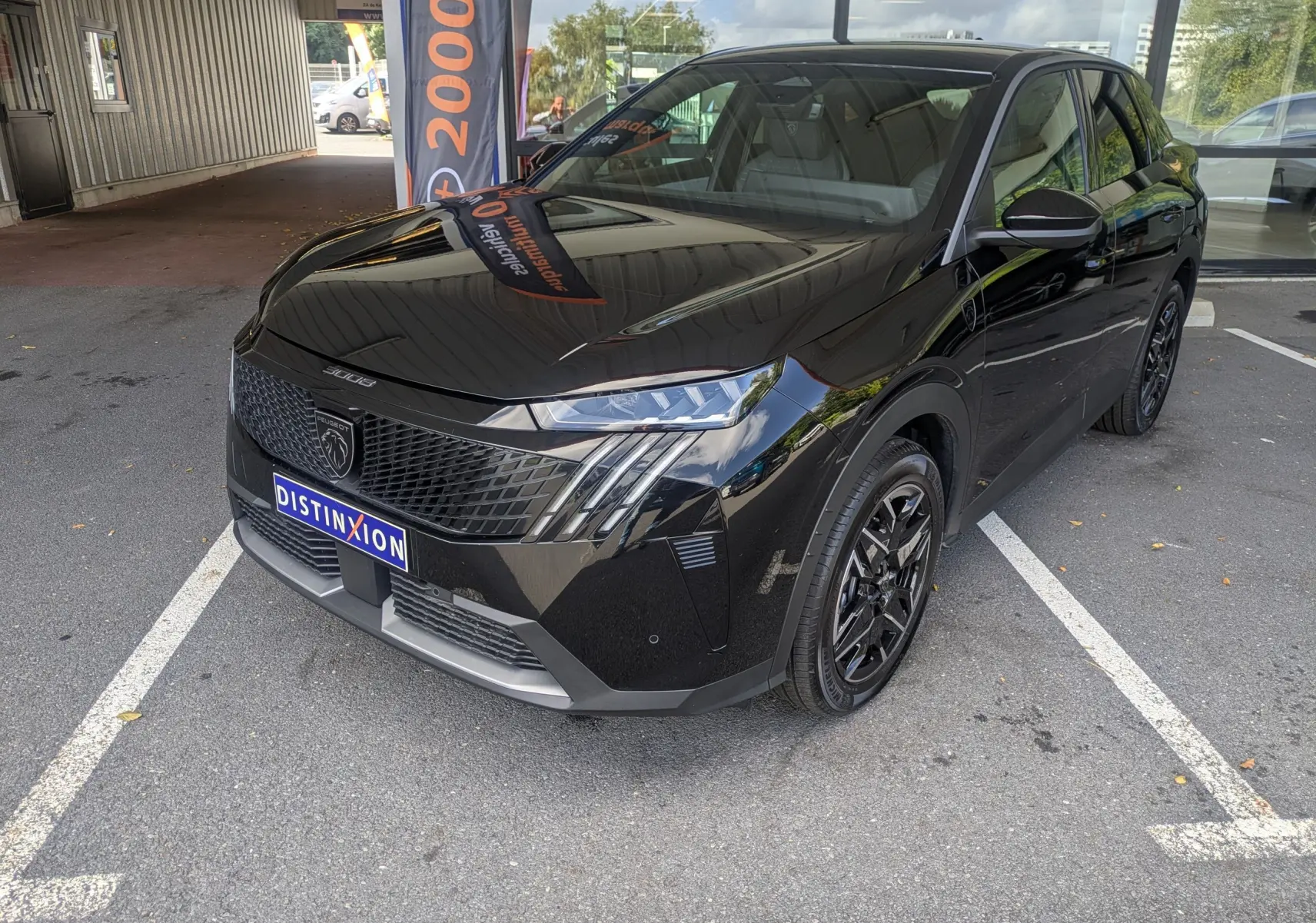 Peugeot 3008 Hybrid 145 GT noir en 3/4 avant droit, avec calandre noire et feux Full LED distinctifs.