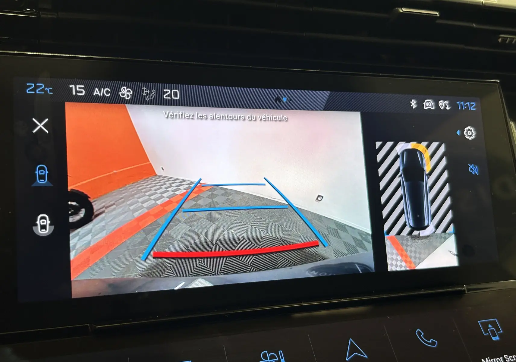 Écran de caméra de recul du Peugeot 308 SW gris Sellenium montrant l'arrière avec lignes de guidage colorées.