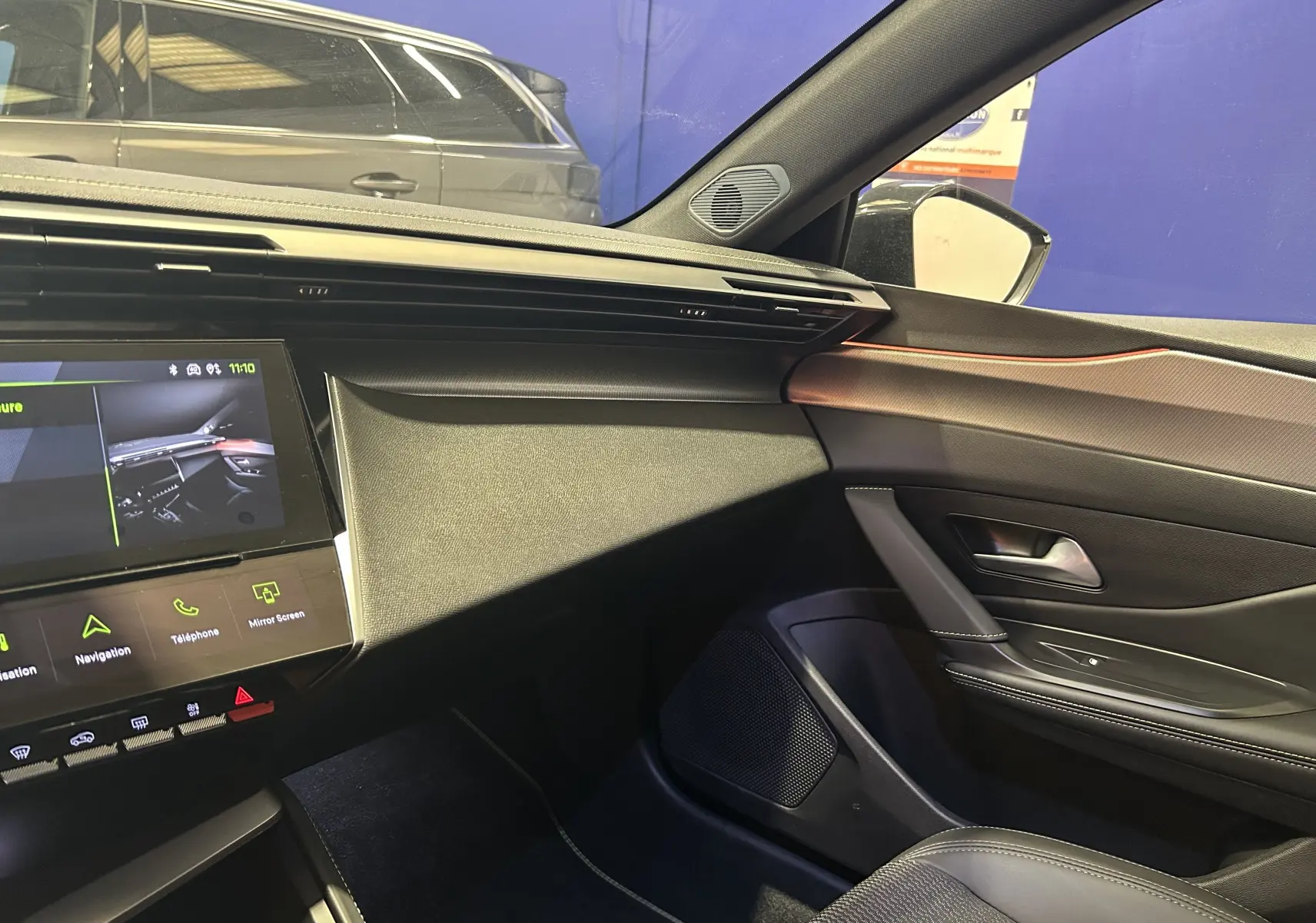 Vue intérieure côté passager de la Peugeot 308 SW 2024 gris Sellenium, avec tableau de bord et écran tactile visible.