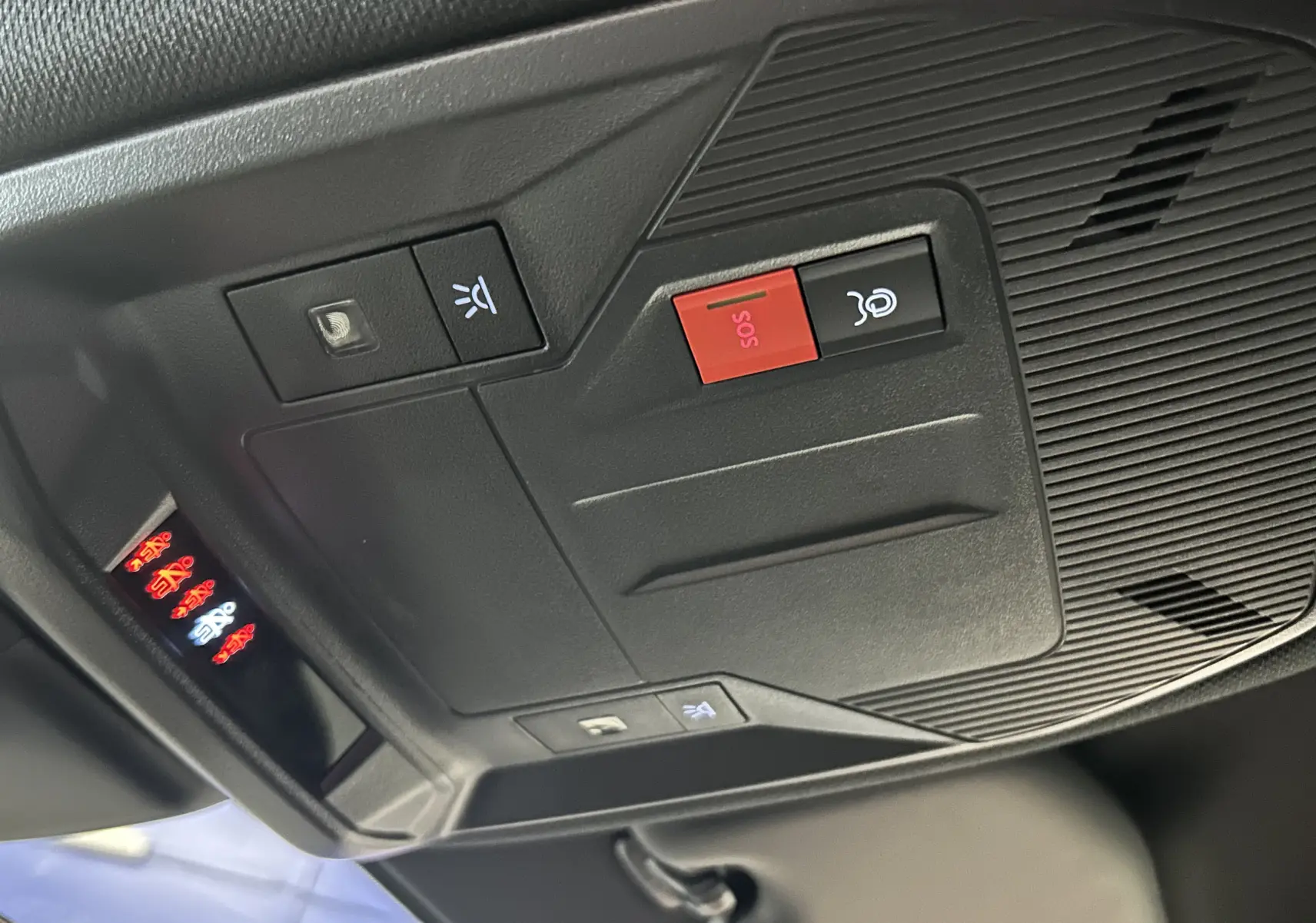 Vue rapprochée du panneau de commandes au plafond intérieur du Peugeot 308 SW 2024 gris Sellenium avec bouton SOS rouge.