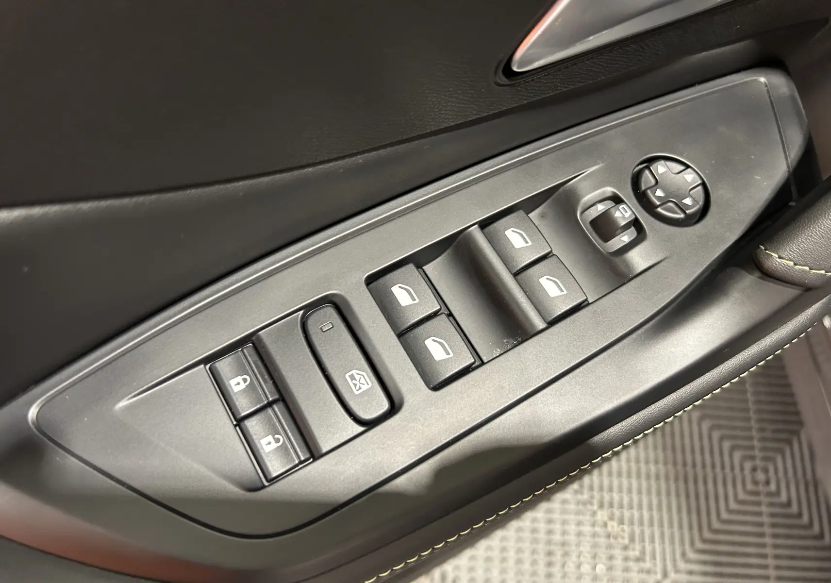 Commande des vitres et rétroviseurs côté conducteur de la Peugeot 308 SW III GT gris Sellenium, avec surpiqûres vertes sur la portière.