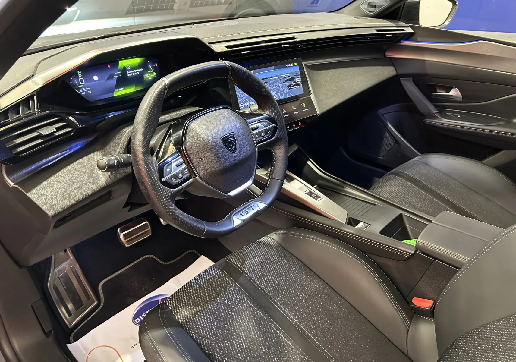 Intérieur moderne de la Peugeot 308 SW 2024, vue côté conducteur, avec volant GT et écran tactile central.