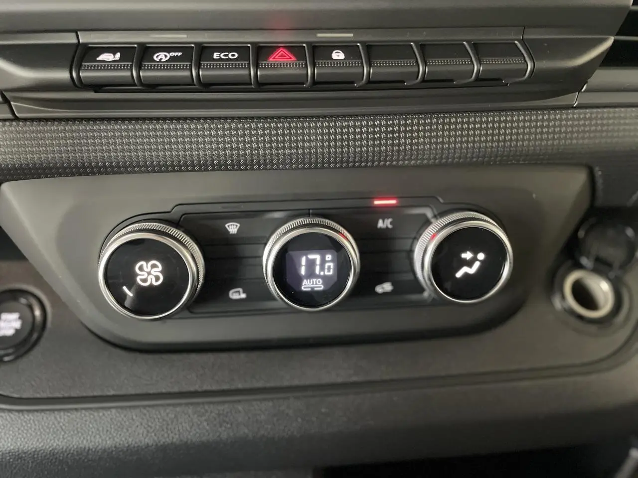 Gros plan sur les commandes de climatisation automatique du Renault Trafic Fourgon gris Comète, affichant 17°C.