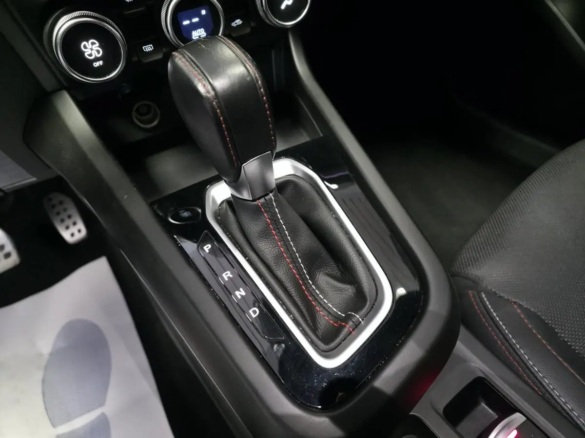 Le levier de vitesses automatique noir avec surpiqûres rouges de la Renault Arkana R.S. Line 2023 vue en gros plan intérieur.