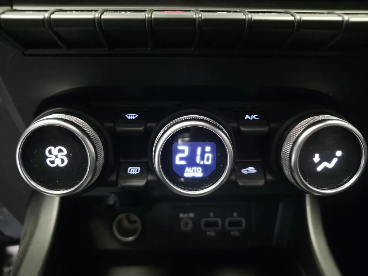 Commandes de climatisation automatique du Renault Arkana R.S. Line 2023 avec affichage digital à 21°C.