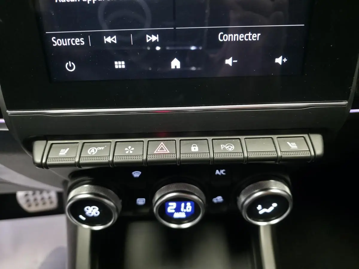 Gros plan sur les commandes de climatisation et boutons multifonctions du tableau de bord noir du Renault Arkana rouge 2023.