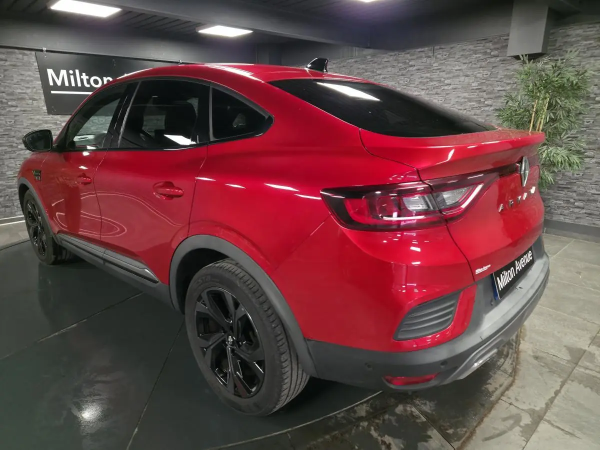Vue 3/4 arrière droite d'une Renault Arkana Rouge Flamme avec jantes noires et toit ouvrant électrique.