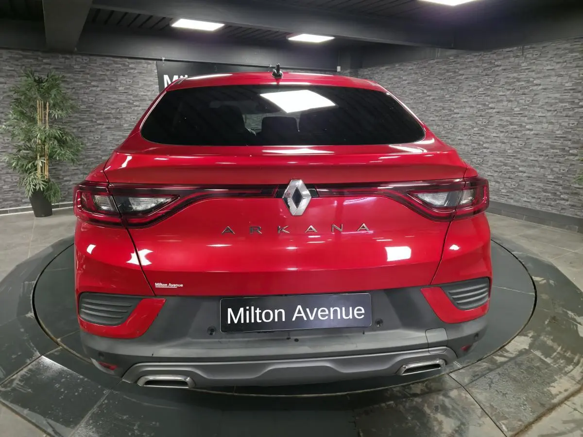 Vue arrière d'une Renault Arkana rouge flamme avec feux reliés et double sortie d'échappement chromée.