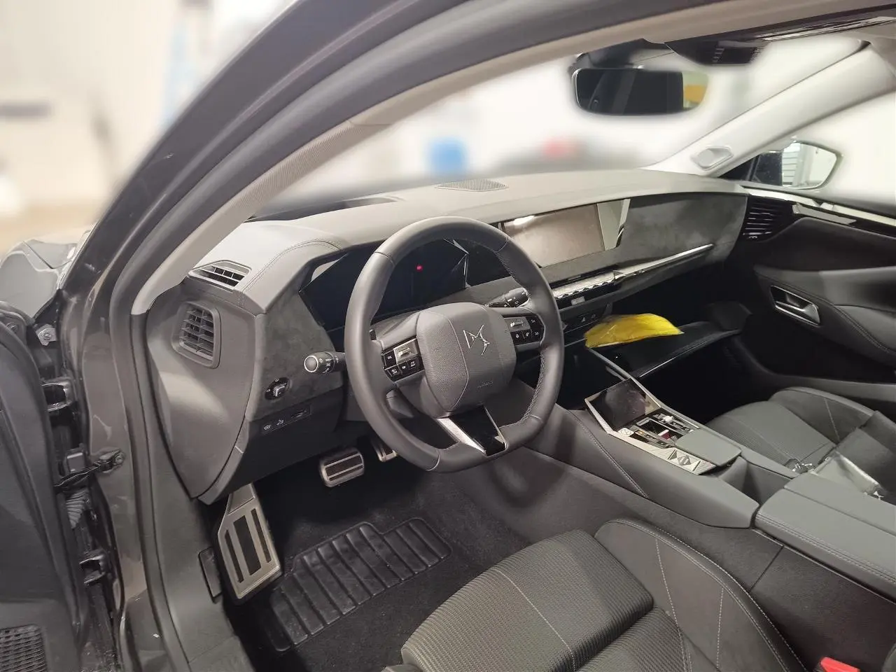Intérieur DS4 2025 gris Platinium vu côté conducteur, volant cuir, tableau de bord moderne et console centrale épurée.