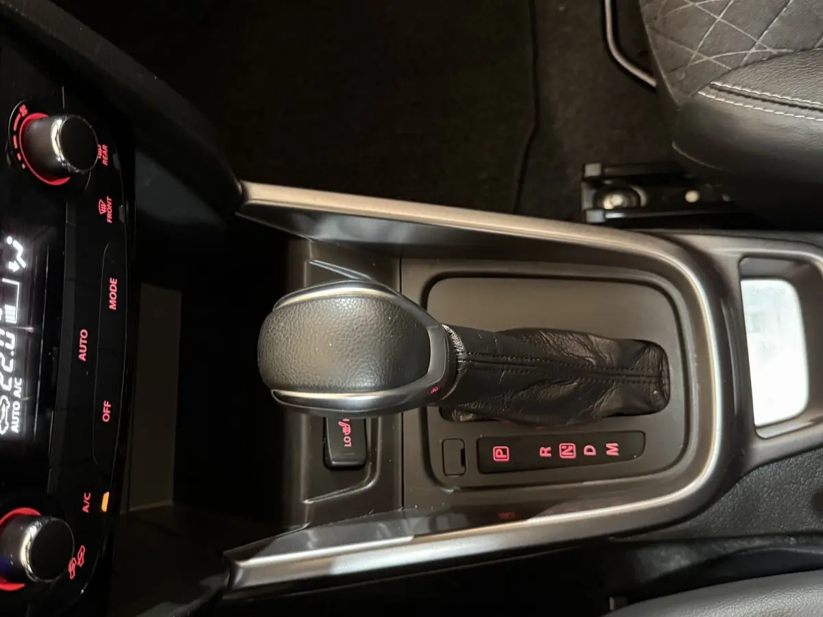 Vue rapprochée de la console centrale du Suzuki Vitara noir, mettant en valeur le levier de vitesse automatique en cuir.
