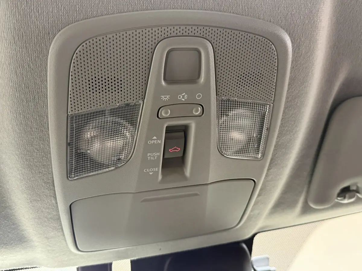 Gros plan sur le panneau de commande du toit ouvrant électrique du Suzuki Vitara noir, intérieur gris clair.