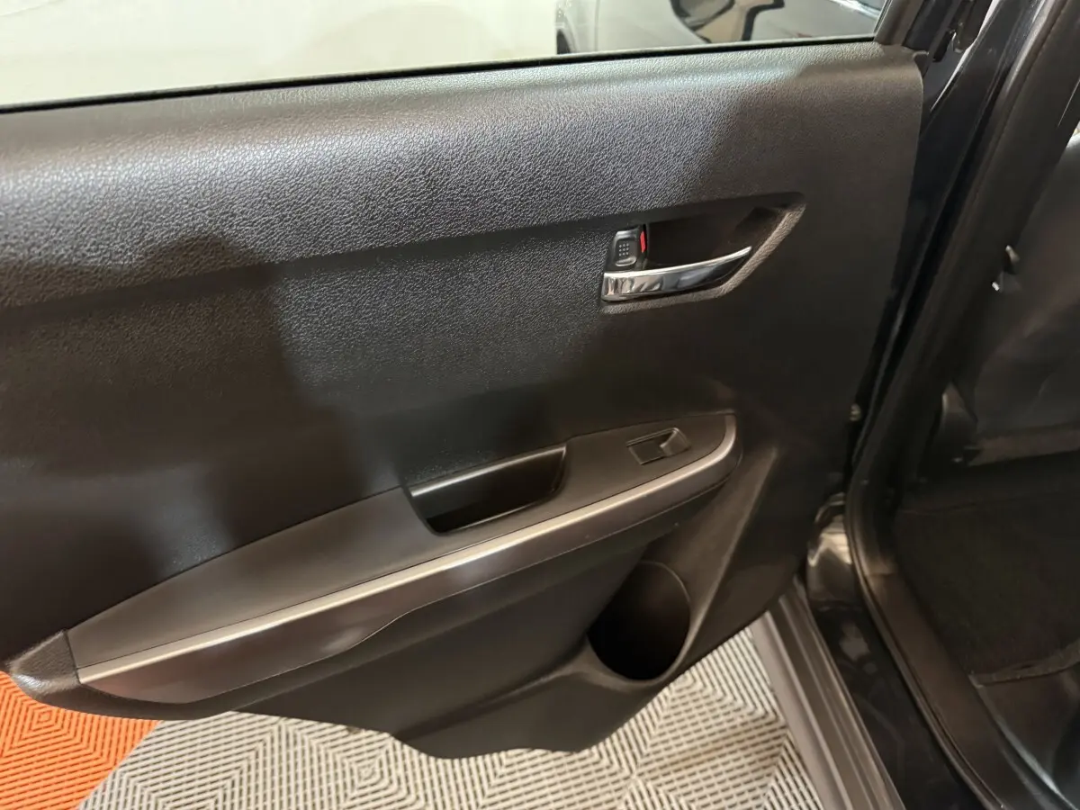 Vue rapprochée de la porte arrière droite noire du Suzuki Vitara 2022, avec poignée chromée et commande de vitre.