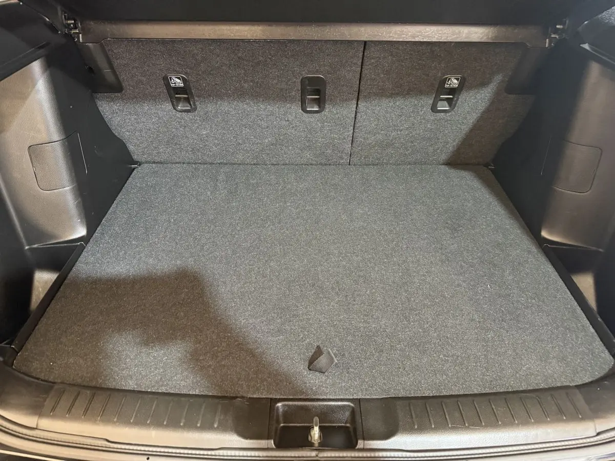 Coffre spacieux du Suzuki Vitara noir vu de face, avec plancher plat et banquette arrière rabattable.