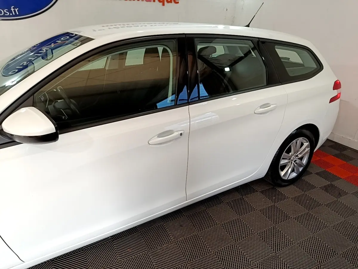 Peugeot 308 break blanc vue de profil côté gauche, avec rétroviseurs électriques et jantes alliage.