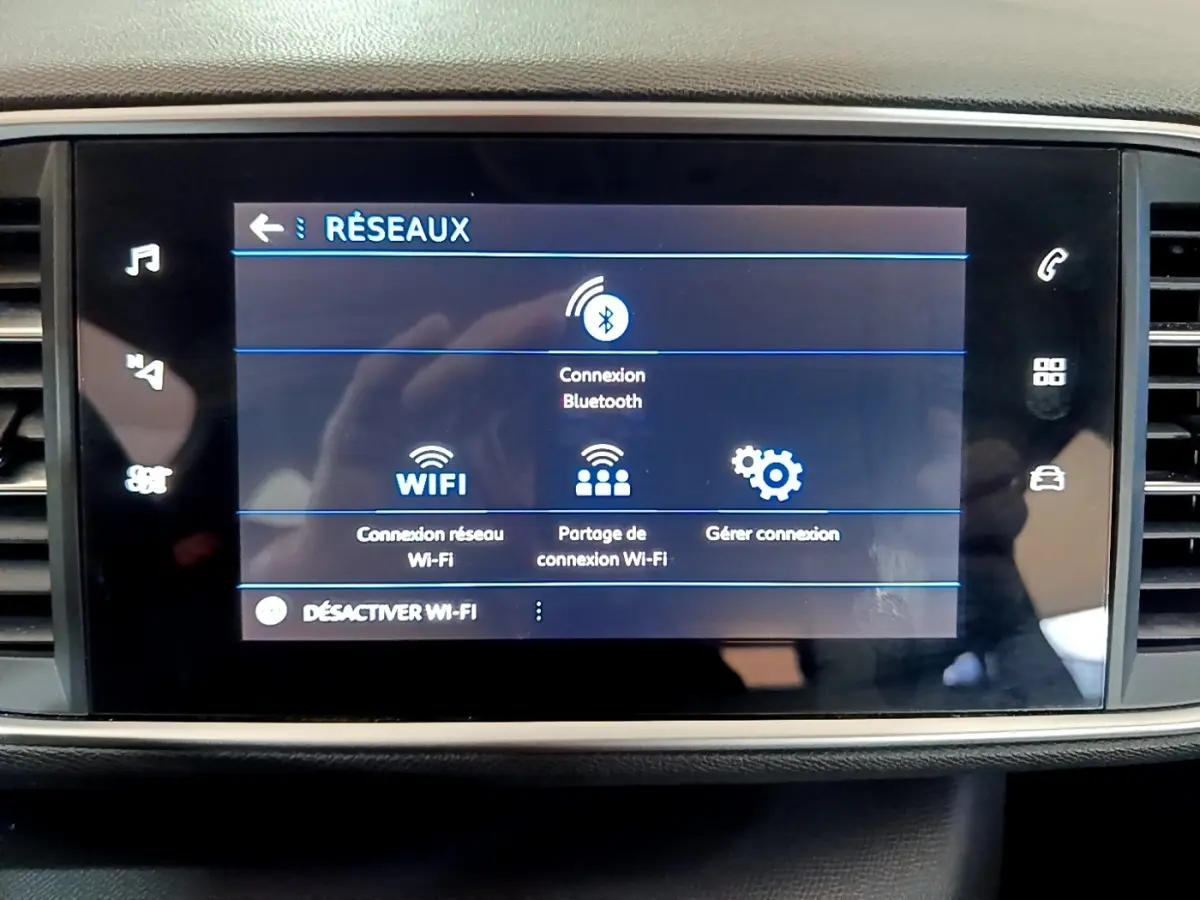Écran tactile central de la Peugeot 308 blanc montrant le menu de connexion Bluetooth et Wi-Fi.