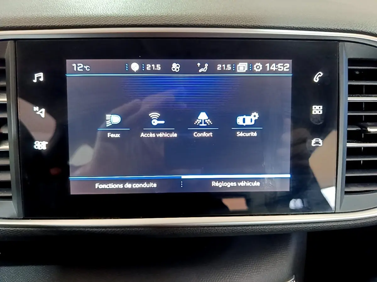 Écran tactile central affichant les réglages du véhicule dans l’habitacle d’une Peugeot 308 blanche de 2021.