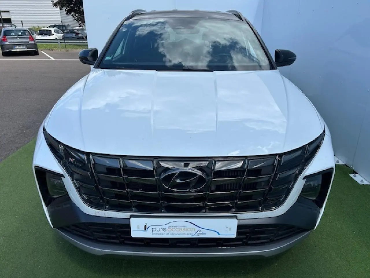 Vue avant d'un Hyundai Tucson blanc polaire avec toit noir et calandre noire au design marqué N-Line.