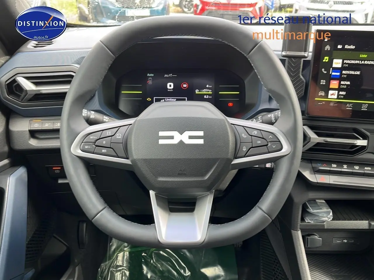 Vue centrée sur le volant multifonction et tableau de bord numérique du Dacia Duster gris schiste 2025.
