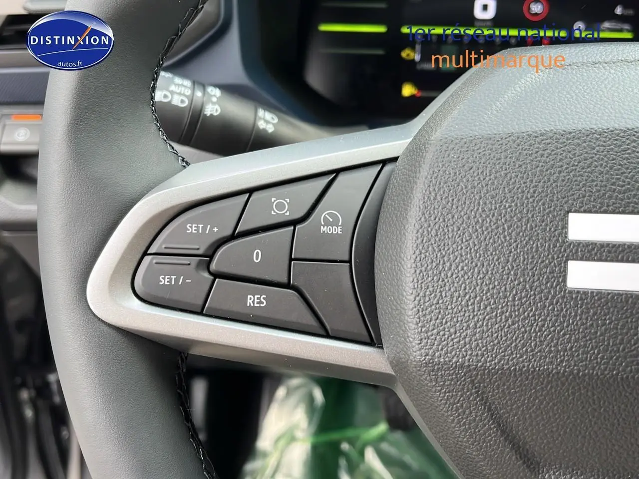 Gros plan sur les commandes de régulateur de vitesse au volant du Dacia Duster 2025 gris schiste.