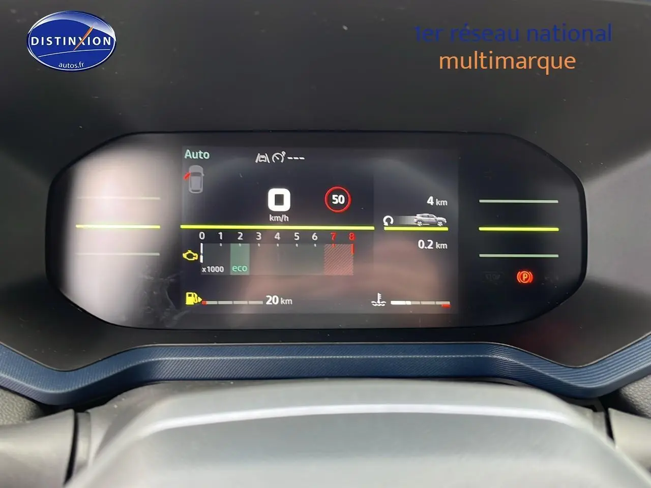 Tableau de bord numérique du Dacia Duster 2025 affichant vitesse, régime moteur et autonomie, vue frontale rapprochée.