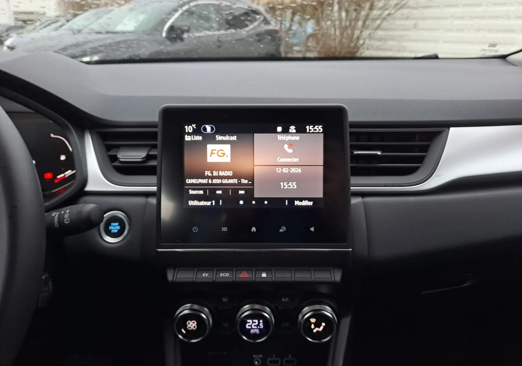 Vue intérieure centrée sur la console centrale du Renault Captur 1.6 E-TECH hybride avec écran tactile et commandes climatisation.