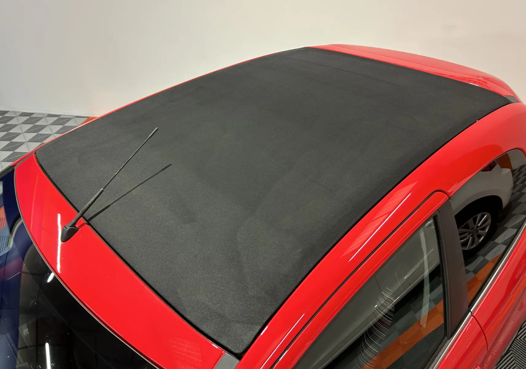 Vue plongeante sur le toit ouvrant noir d'une Citroën C1 rouge, mettant en valeur la capote Airscape fermée.