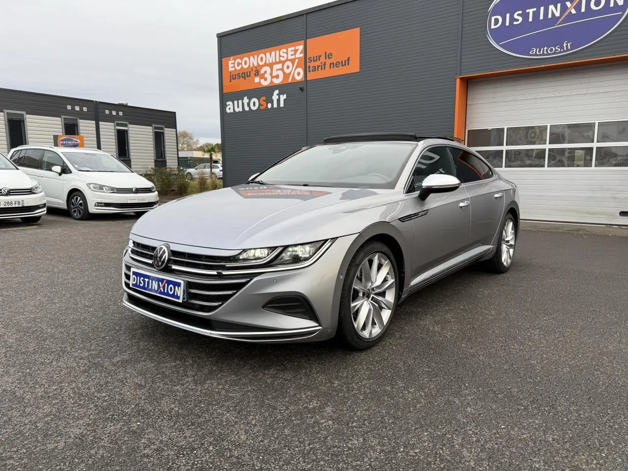 Volkswagen Arteon gris pyrite métallisé vue 3/4 avant droit avec jantes alliage 19 pouces devant un garage autos.fr