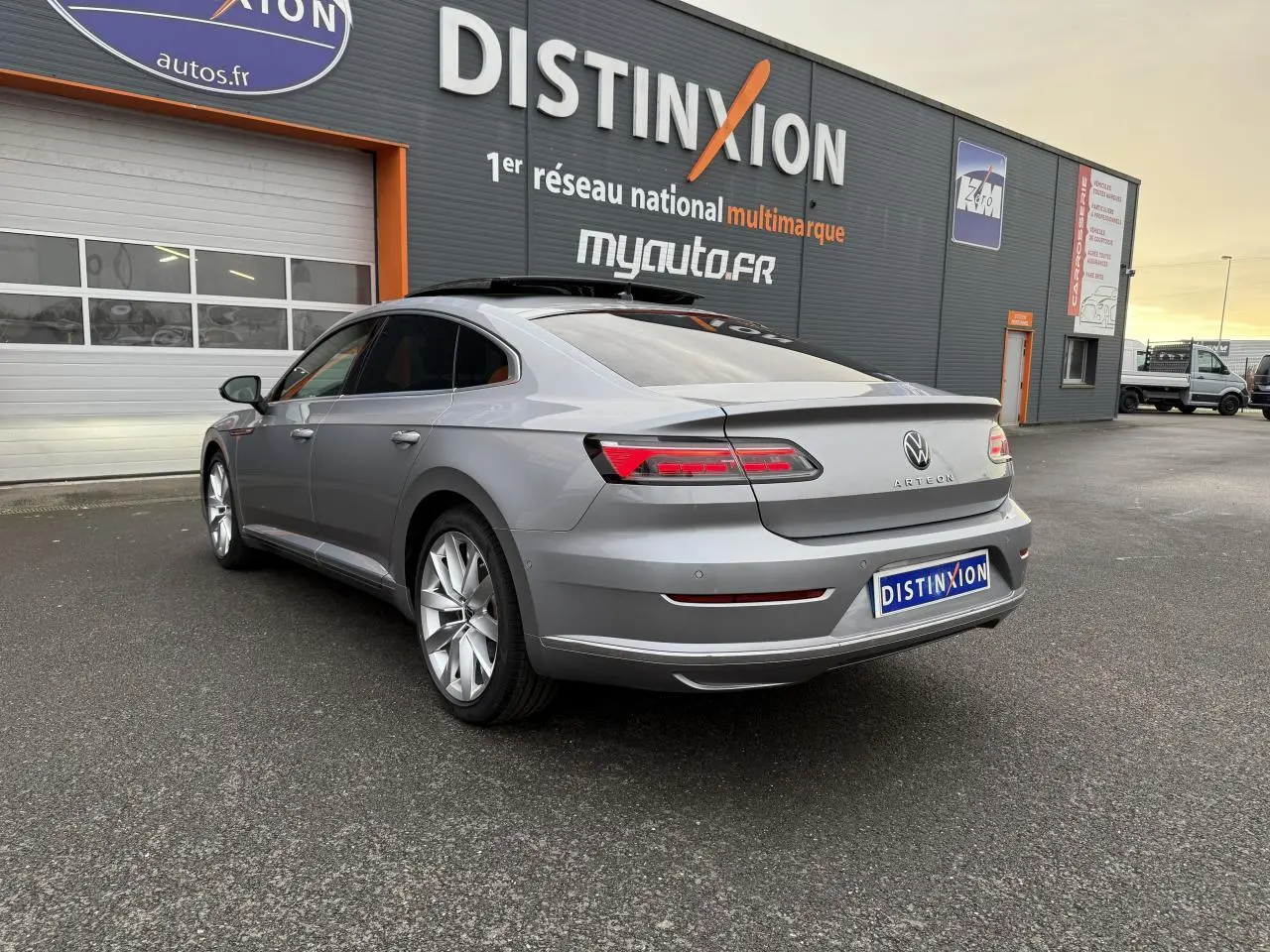 Volkswagen Arteon gris pyrite métallisé vue 3/4 arrière droit avec toit ouvrant panoramique ouvert.
