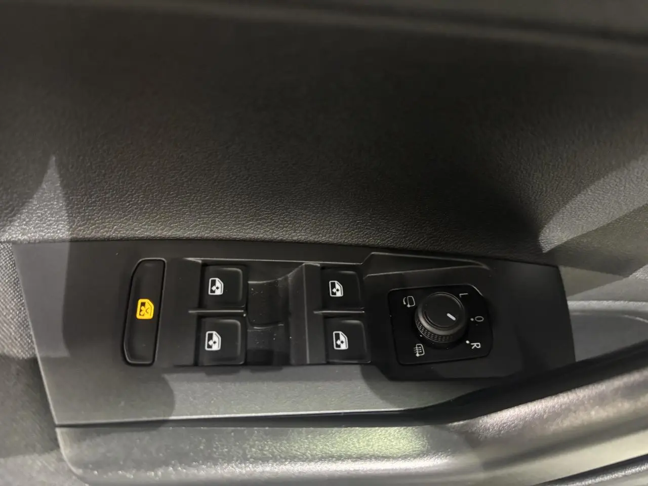 Panneau de commandes des vitres et rétroviseurs côté conducteur du Volkswagen Taigo blanc 2023, intérieur noir.