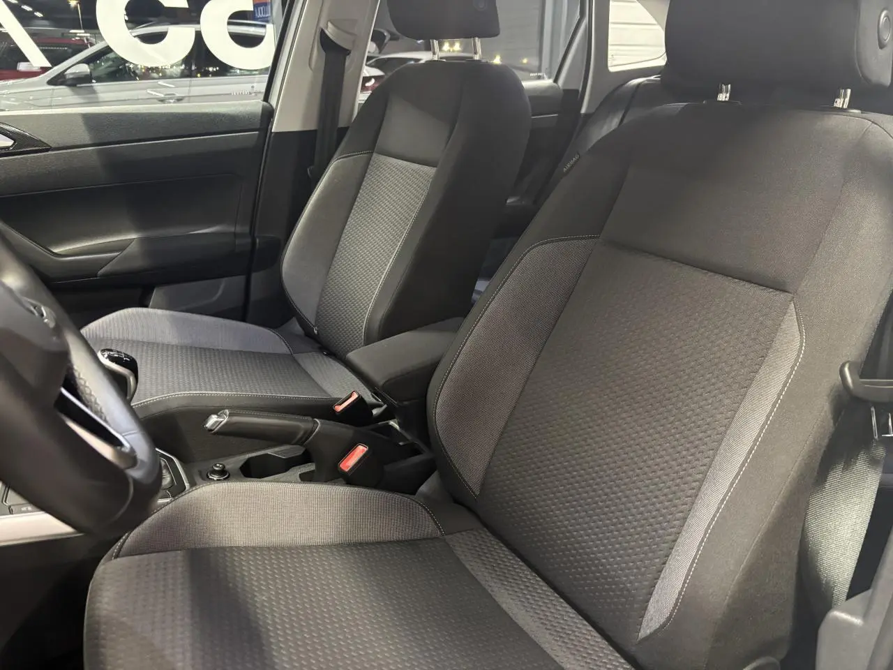 Vue intérieure côté gauche montrant les sièges avant en tissu gris foncé du Volkswagen Taigo 2023.