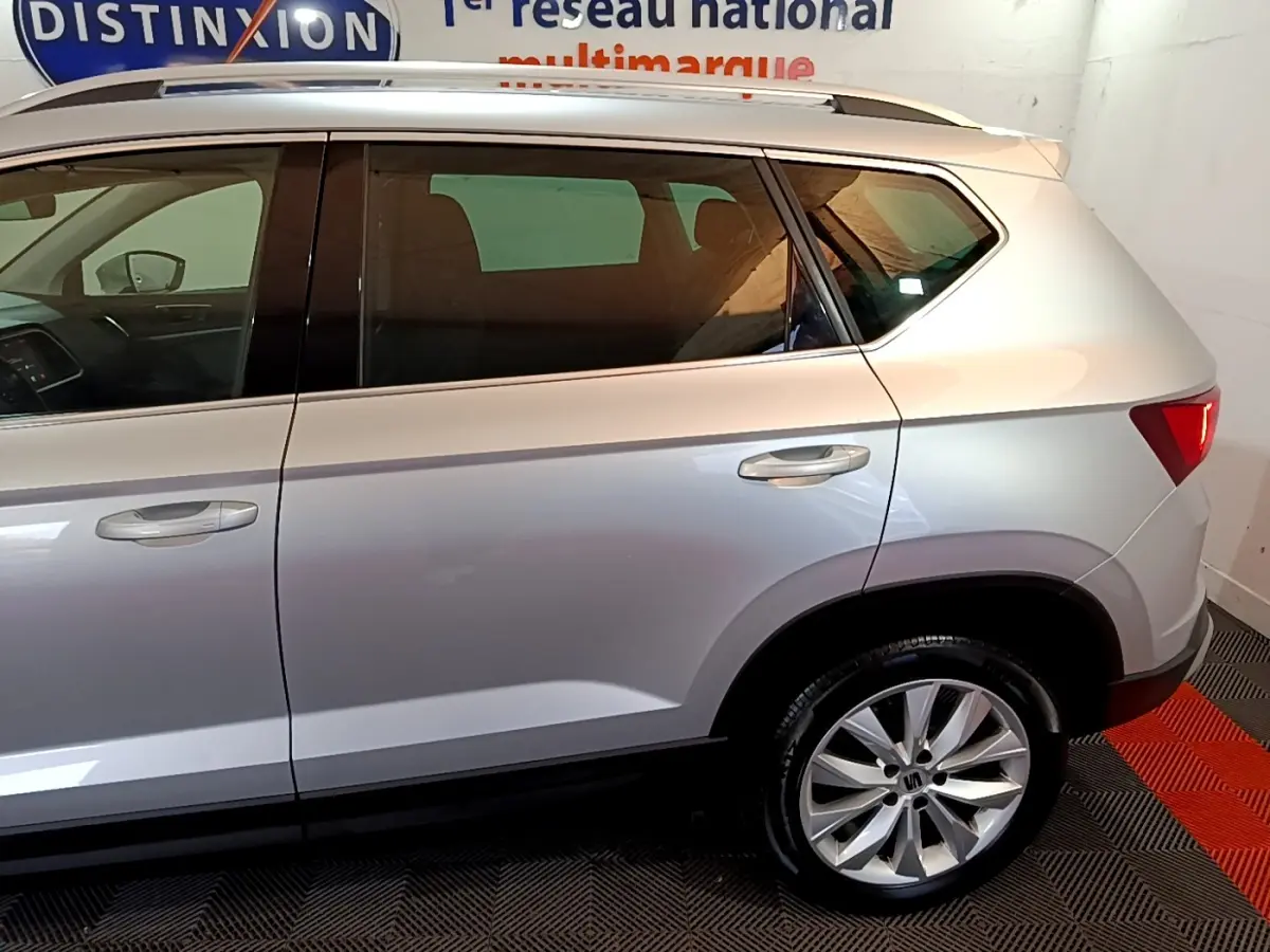 Vue latérale droite d'un SEAT Ateca gris clair, mettant en valeur la porte arrière et la roue avec jante alu.