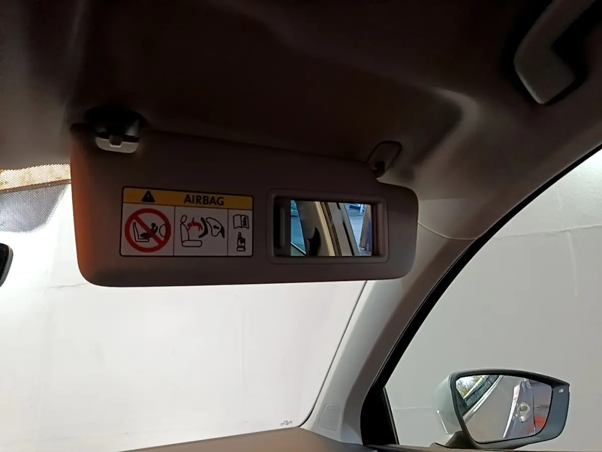 Détail du pare-soleil côté conducteur avec miroir intégré et avertissement airbag, intérieur gris clair du SEAT Ateca.