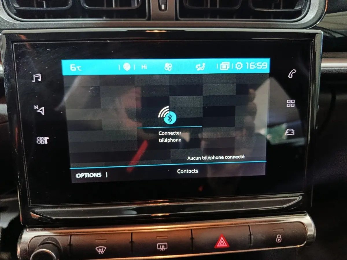 Écran tactile central de la Citroën C3 2024 gris foncé affichant la connexion Bluetooth, avec commandes climatisation en dessous.