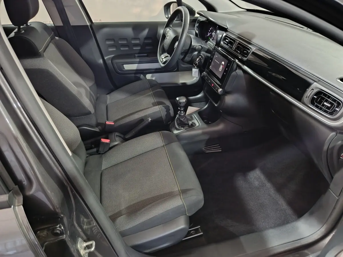 Intérieur avant de la Citroën C3 gris foncé 2024, vue côté conducteur avec tableau de bord et écran tactile central.