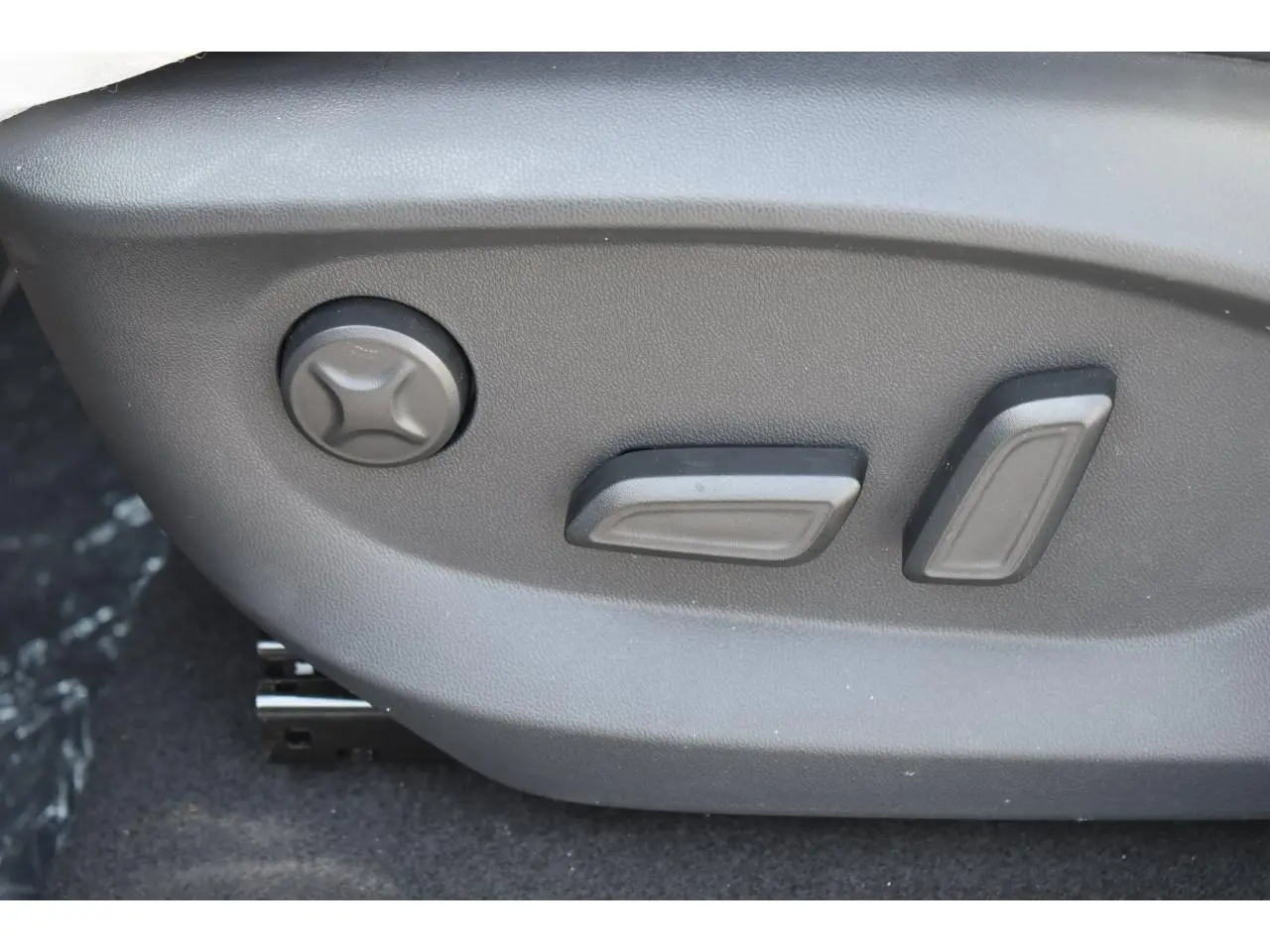 Gros plan sur les commandes de réglage électrique du siège conducteur du MG MOTOR EHS blanc, version Luxury 2026.