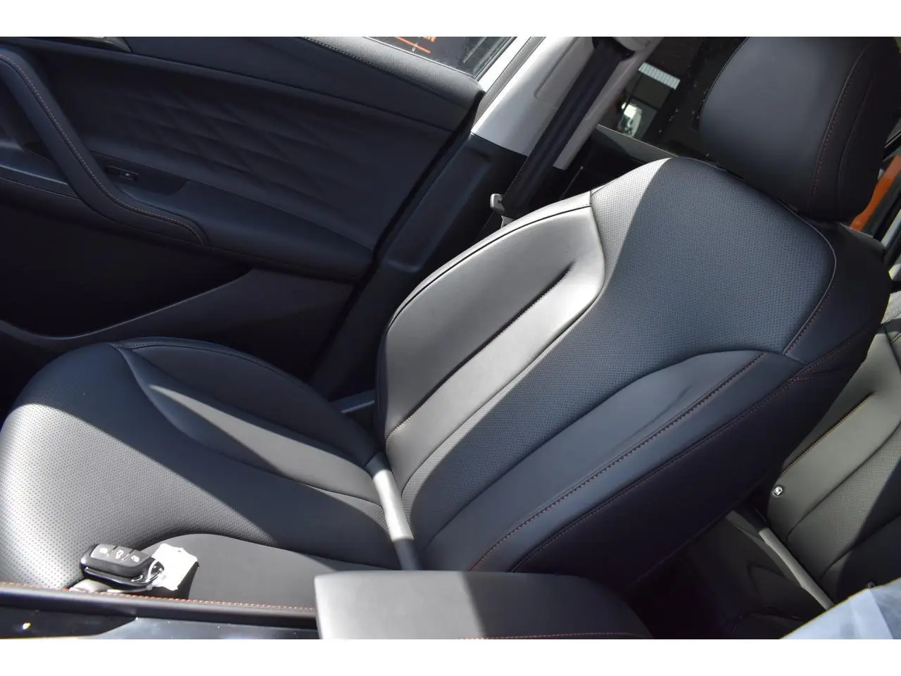 Vue rapprochée du siège avant droit en cuir noir avec surpiqûres marron du MG Motor EHS 1.5 Hybrid+ 224 ch Luxury blanc.