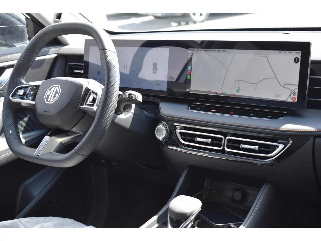 Vue intérieure côté conducteur du MG Motor EHS blanc 2026, avec volant multifonction et écran tactile panoramique.