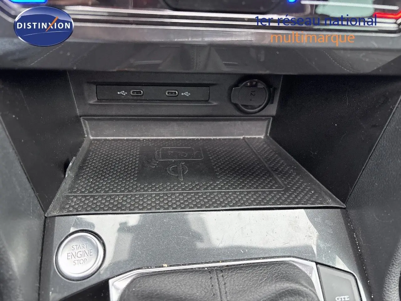 Détail de la console centrale du Volkswagen Tiguan 1.4 E-Hybrid 2022 avec bouton start/stop et zone de recharge sans fil.