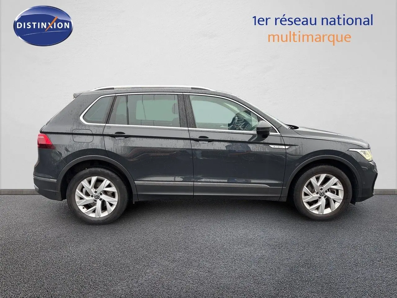 Volkswagen Tiguan 1.4 E-HYBRID gris lunaire vu de profil côté gauche sur fond neutre.