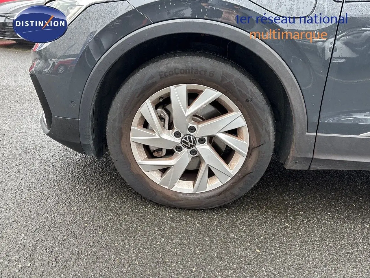 Gros plan sur la roue avant gauche du Volkswagen Tiguan gris lunaire, mettant en valeur la jante alliage et le pneu EcoContact 6.