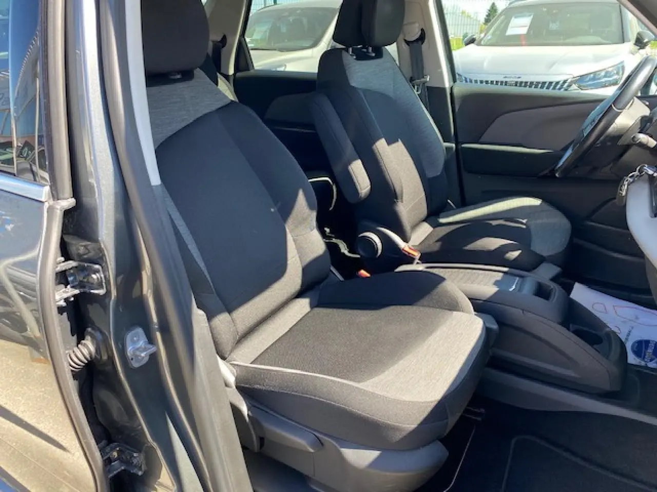 Vue intérieure côté gauche des sièges avant en tissu gris et noir d'une Citroën C4 Picasso gris shark 2016.