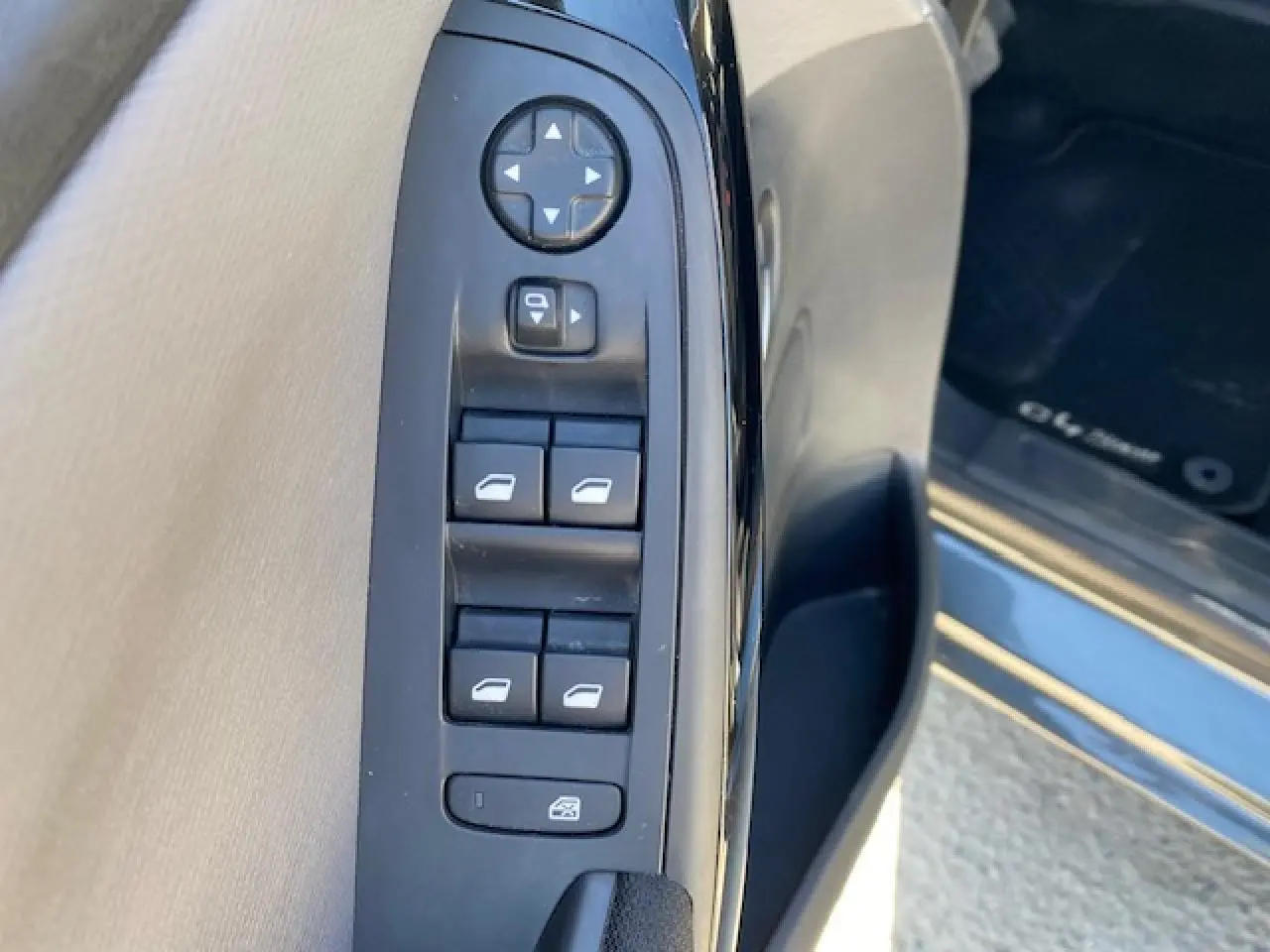 Gros plan sur les commandes de lève-vitres et rétroviseurs côté gauche d'une Citroën C4 Picasso gris Shark 2016.