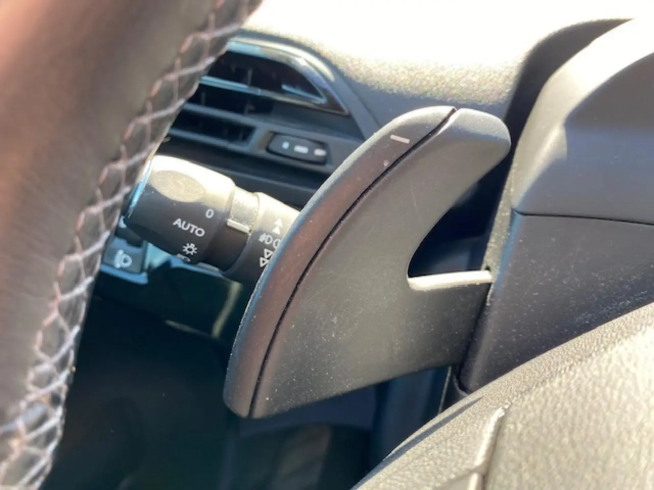 Gros plan sur la palette de commande de boîte au volant côté gauche du Citroën C4 Picasso gris Shark.